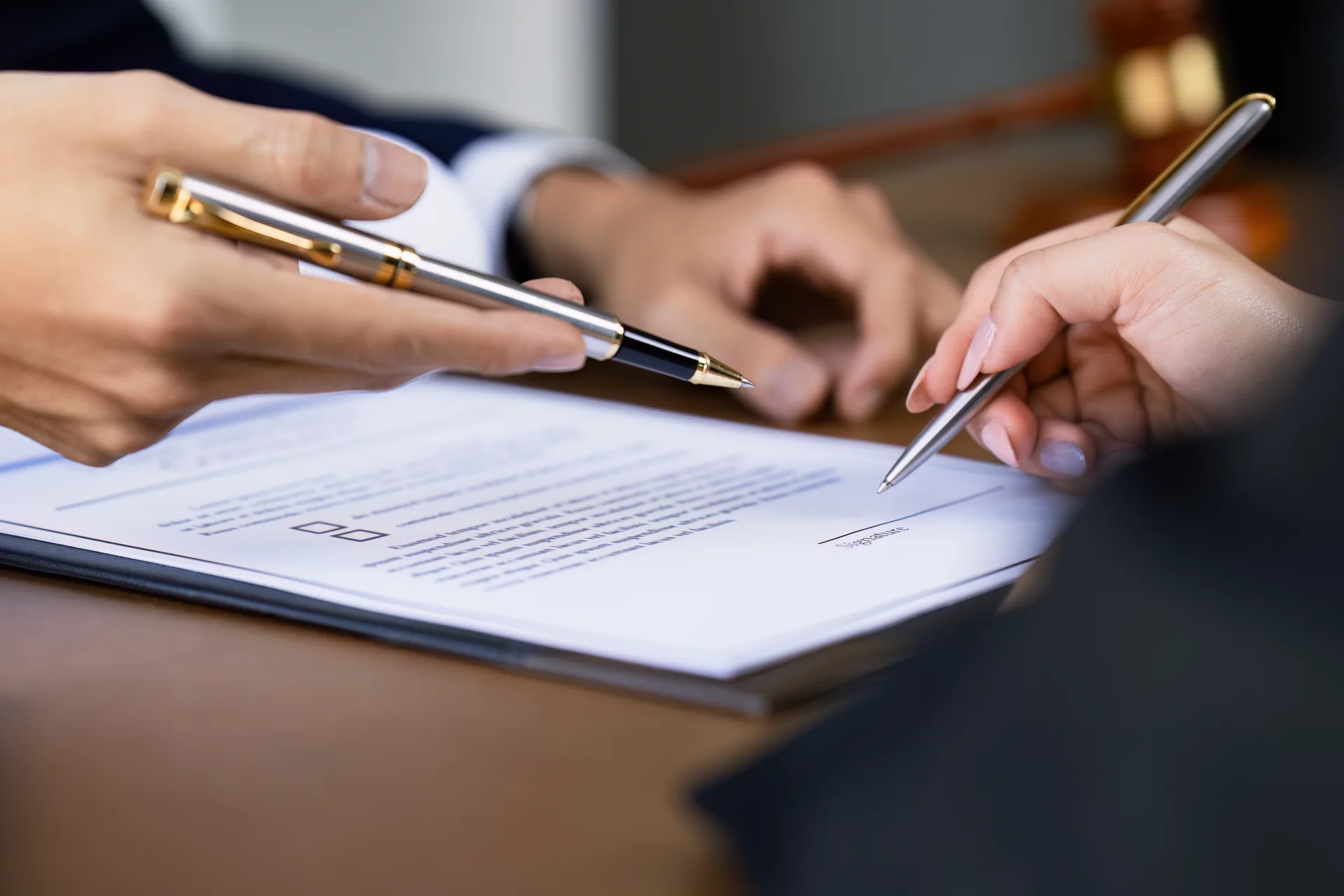 Firma de un contrato inmobiliario sobre un escritorio